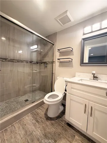 a bathroom with a sink a toilet and shower