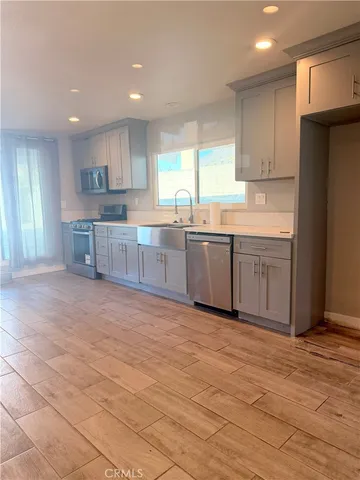 a large kitchen with cabinets and wooden floor