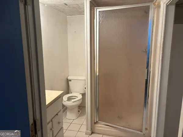 a bathroom with a granite countertop toilet and a sink
