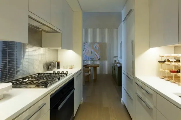 a kitchen with a stove and a wooden floor