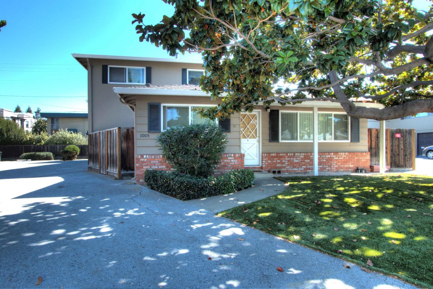 a front view of a house with a yard and potted plants