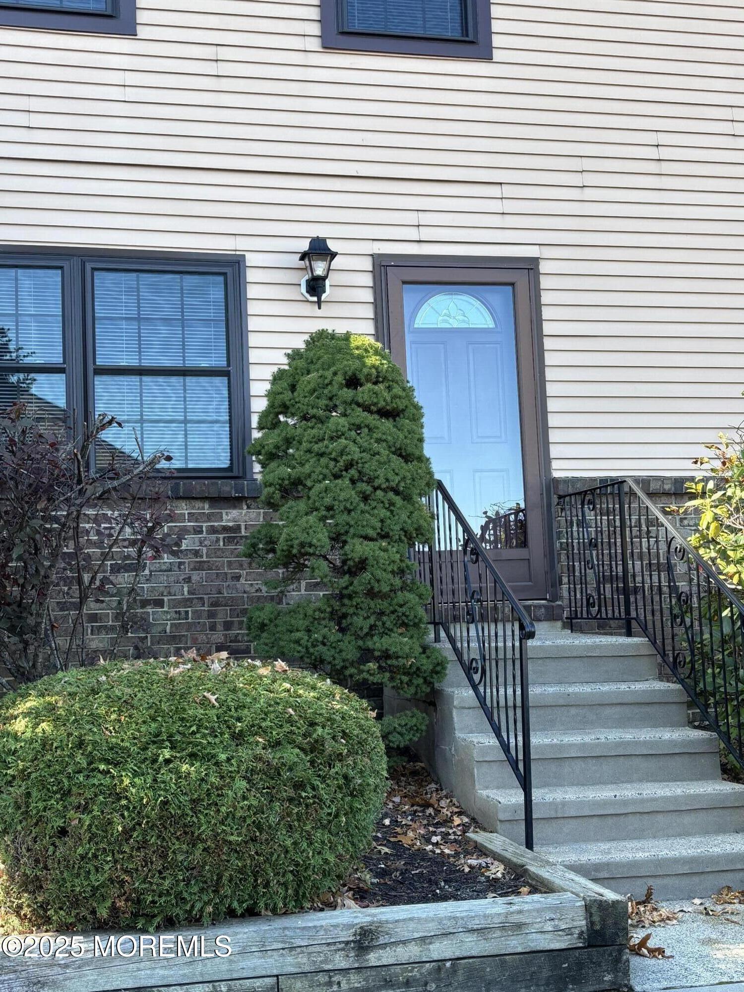159 Village Green Way Hazlet, NJ 07730 - Photo 1 of 17 a view of a house with a small yard and wooden floor and fence