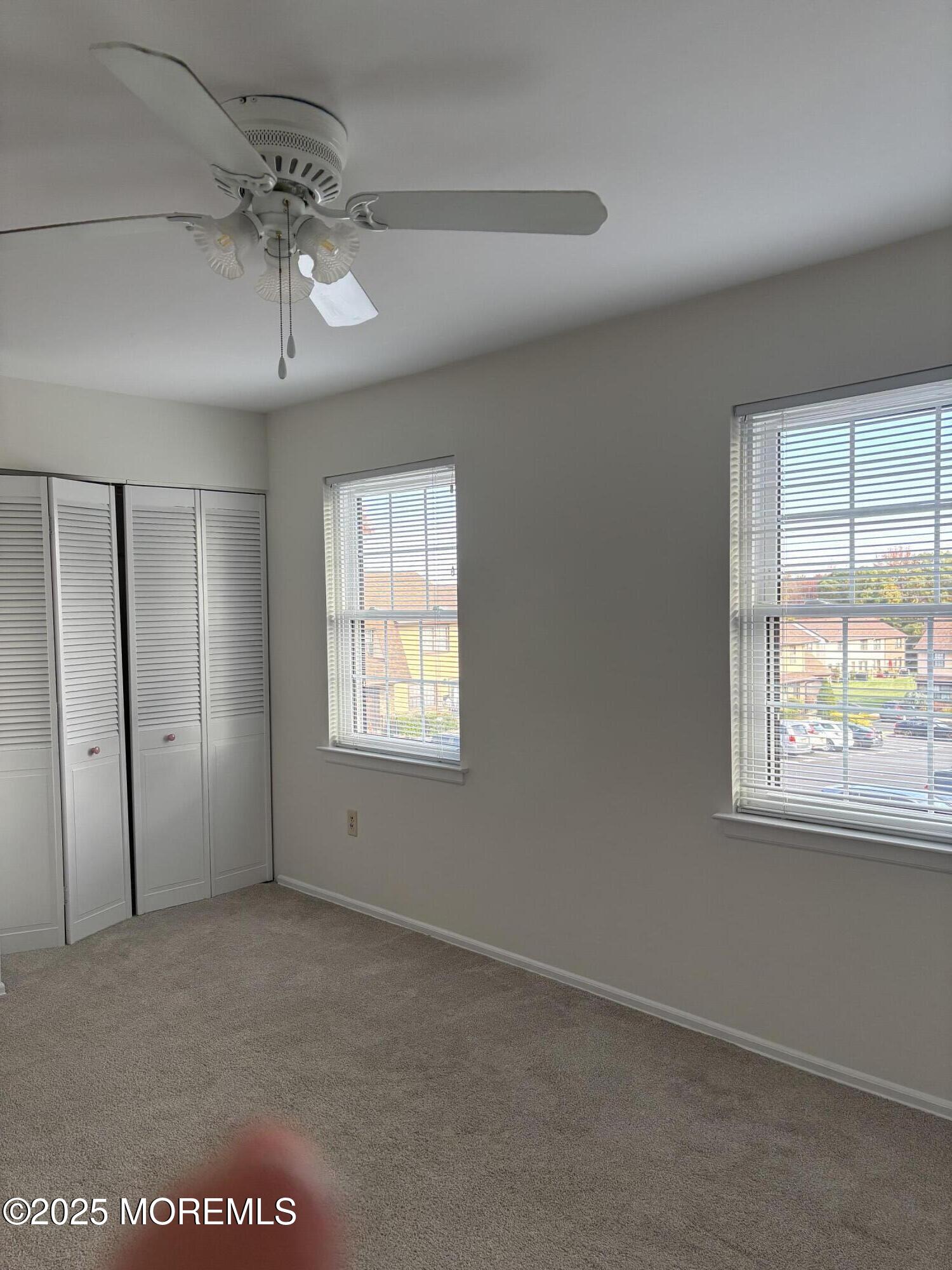 159 Village Green Way Hazlet, NJ 07730 - Photo 11 of 17 en empty room with windows and chandelier fan