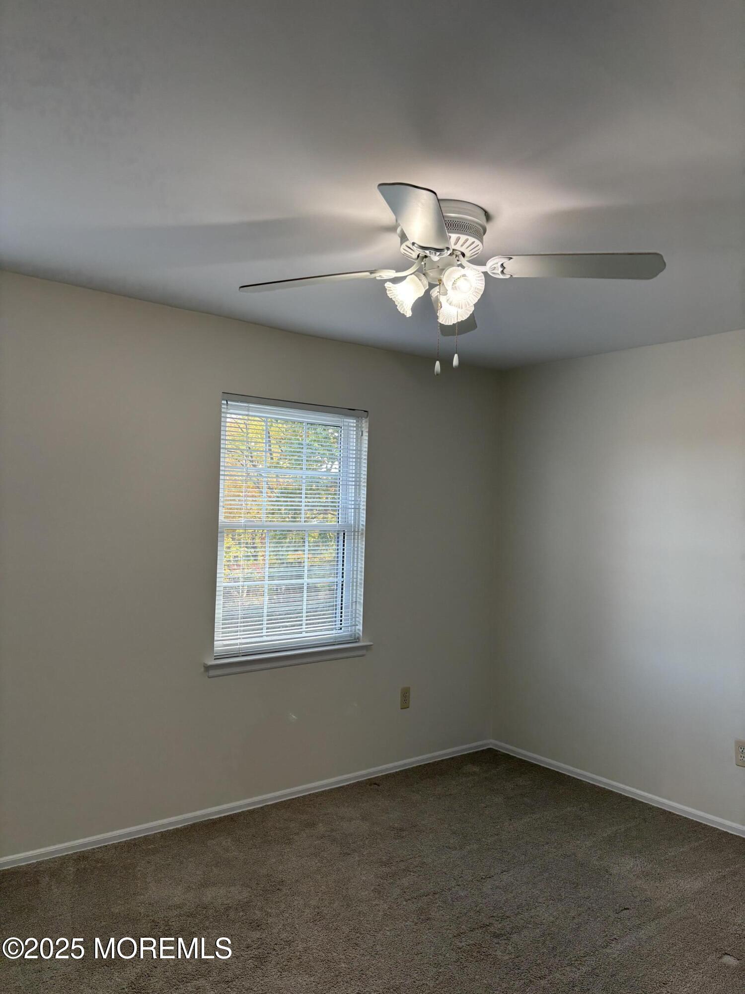 159 Village Green Way Hazlet, NJ 07730 - Photo 14 of 17 an empty room with a window and a fan