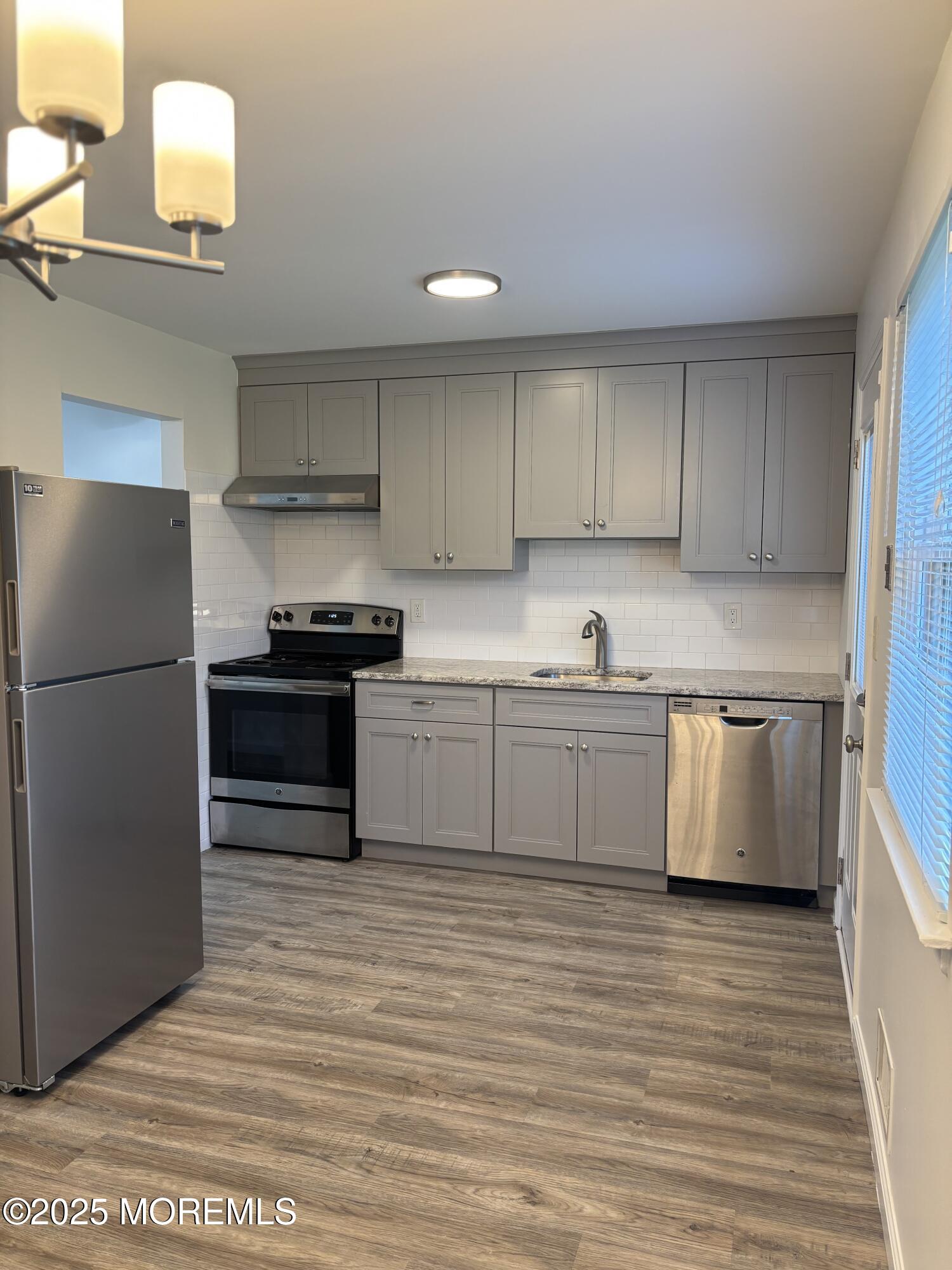 159 Village Green Way Hazlet, NJ 07730 - Photo 6 of 17 a kitchen with stainless steel appliances granite countertop a stove a sink and a refrigerator
