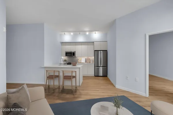 a kitchen with a table chairs refrigerator and microwave