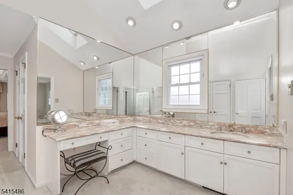a bathroom with a tub shower sink and mirror