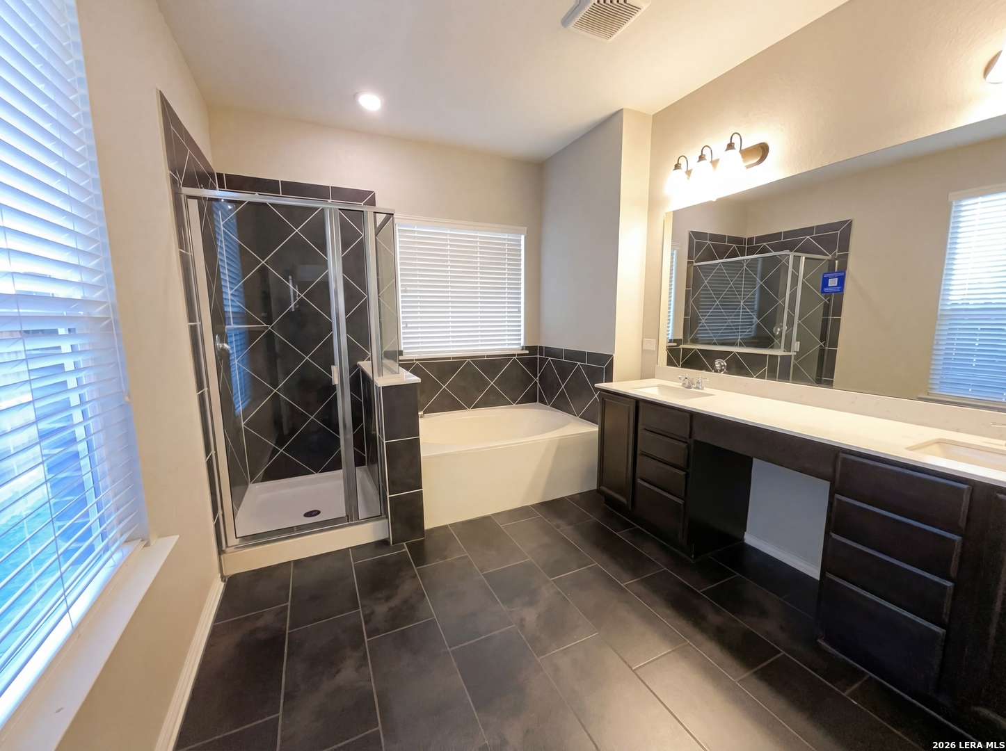 11403 Sawyer Road San Antonio, TX 78238 - Photo 14 of 20 a spacious bathroom with a double vanity sink a mirror and a shower
