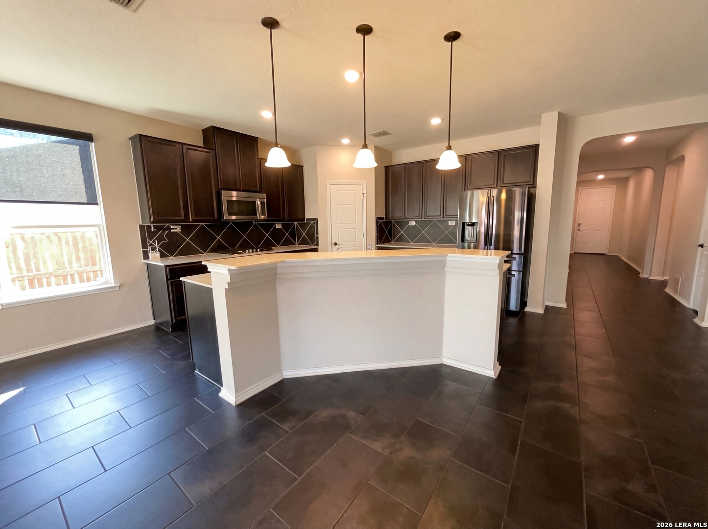 11403 Sawyer Road San Antonio, TX 78238 - Photo 17 of 20 a view of a kitchen with kitchen island stainless steel appliances a stove a refrigerator a sink a oven a dining table and chairs