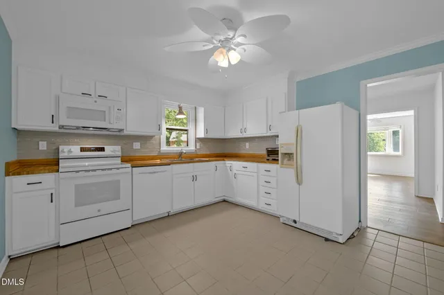 a kitchen with white cabinets and white appliances