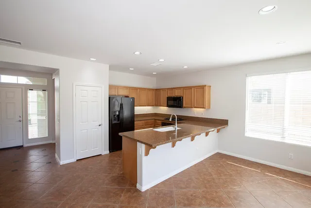 a kitchen with stainless steel appliances granite countertop a sink and a refrigerator