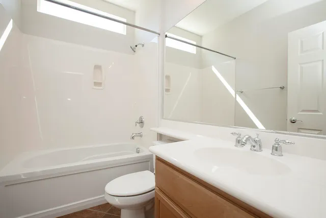 a bathroom with a sink a mirror toilet and bathtub