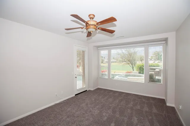 a view of empty room with window and ceiling fan