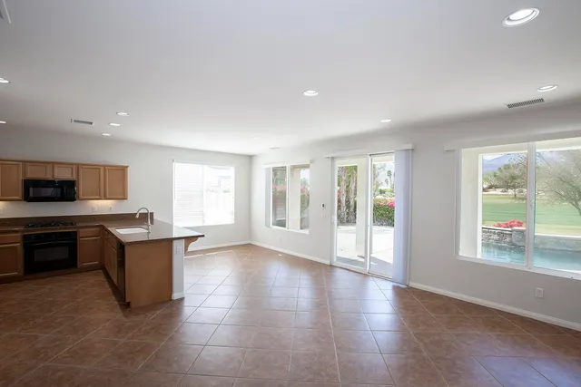 a living room with couches and kitchen view with wooden floor