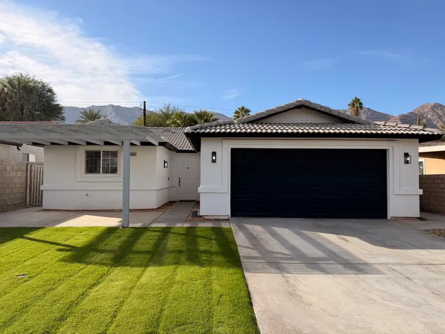 a front view of a house with a yard and garage