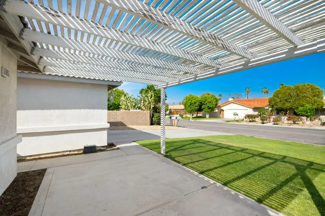 a patio with table and chairs and potted plants