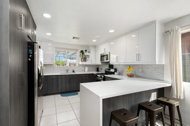 a kitchen with stainless steel appliances granite countertop a sink a stove a counter space and cabinets