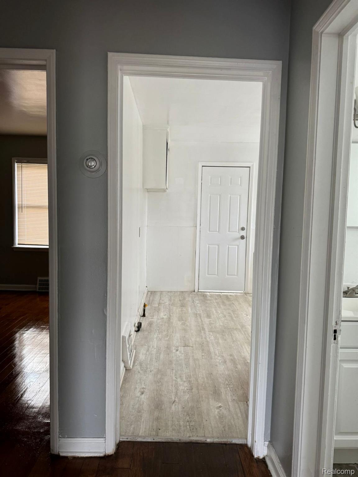 19706 Moross Road Detroit, MI 48224 - Photo 8 of 13 Passageway with dark wood-finish flooring transitioning to light wood-finish flooring