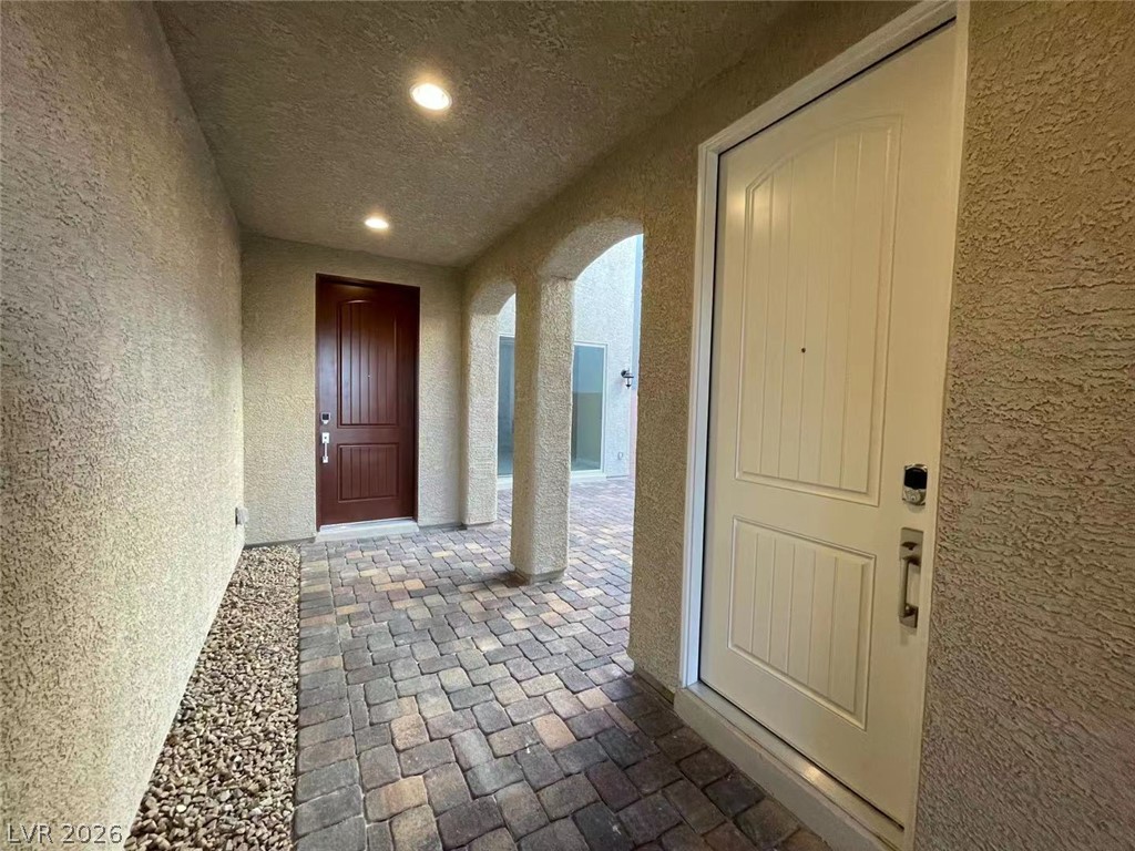11 Rancho Maria Street Las Vegas, NV 89148 - Photo 3 of 27 An inviting covered entry features elegant arched openings, recessed lighting, and classic paver flooring.
