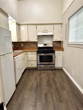 a kitchen with a stove oven and white cabinets