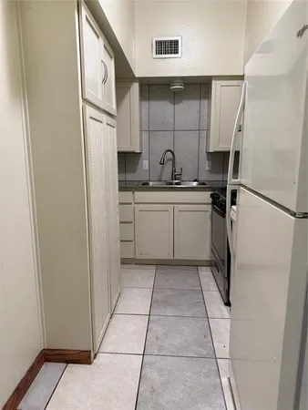 a kitchen with a refrigerator and a sink