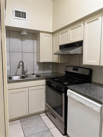 a kitchen with stainless steel appliances granite countertop a sink and a stove