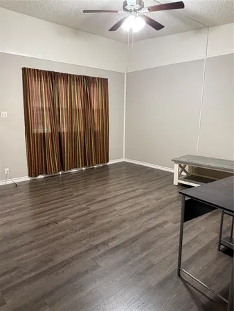 an empty room with wooden floor table and chairs
