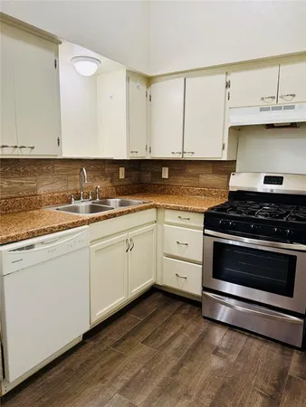 a kitchen with granite countertop white cabinets and appliances