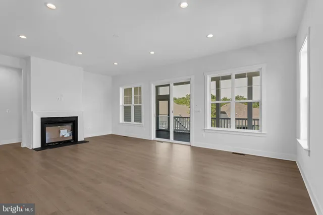 a view of an empty room with a window and fireplace