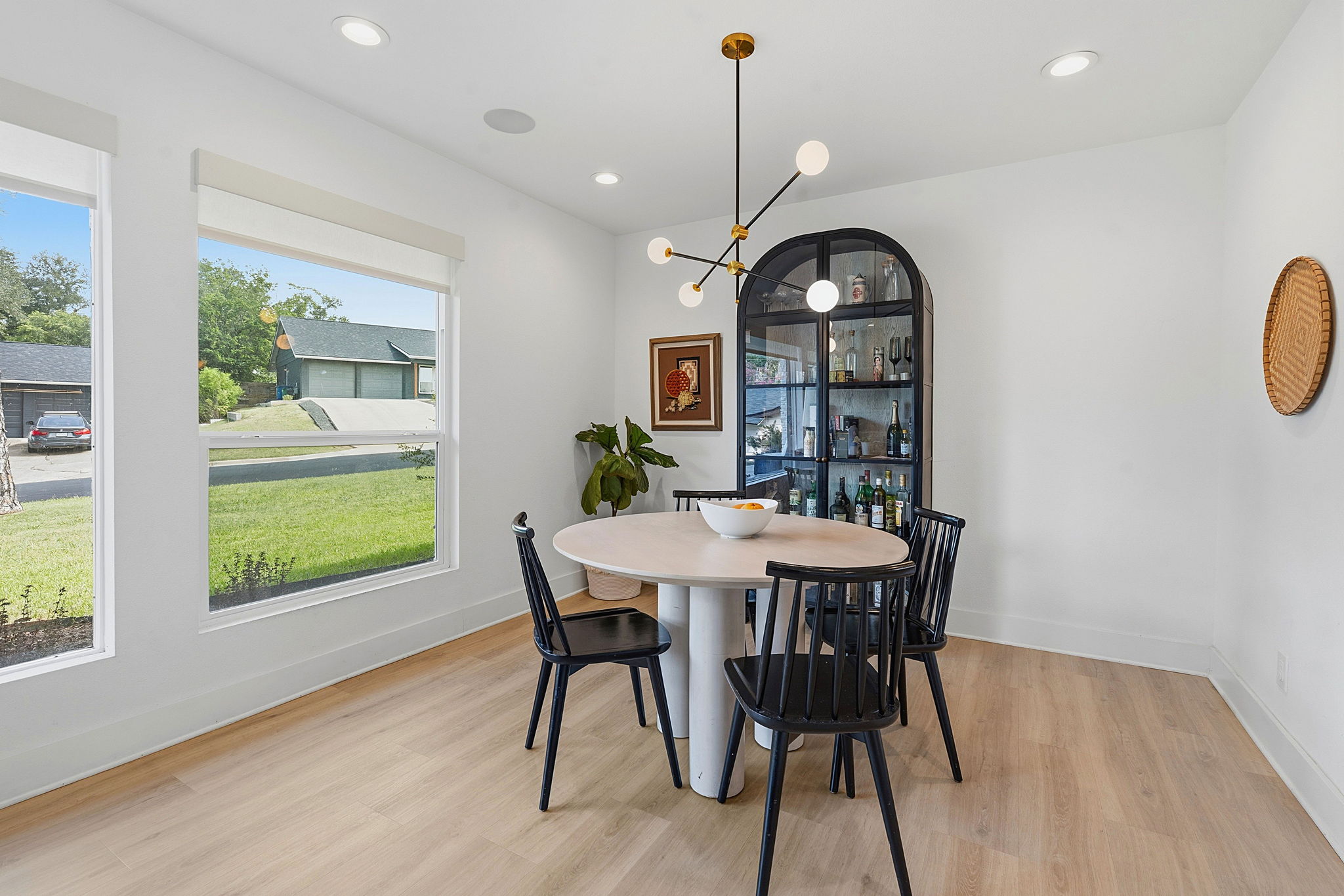 4403 Elmsgrove Drive Austin, TX 78721 - Photo 29 of 38 Clean lines and a modern chandelier elevate this intimate dining space, bathed in natural light from broad windows.
