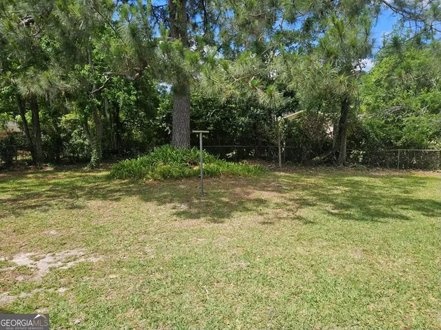a backyard of a house with lots of plants and tree