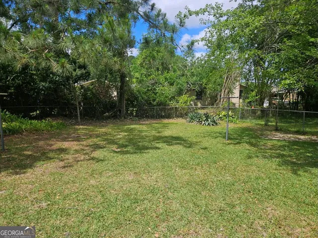 a view of a backyard with plants and a fountain