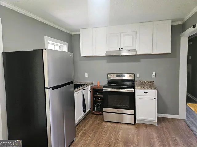 a kitchen with stainless steel appliances a refrigerator a stove top oven and cabinets