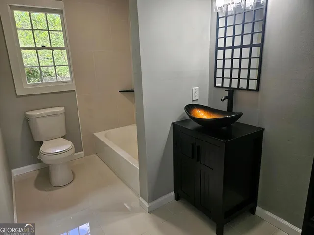 a bathroom with a toilet a sink and window