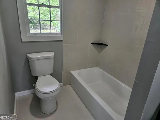 a bathroom with a toilet and a window