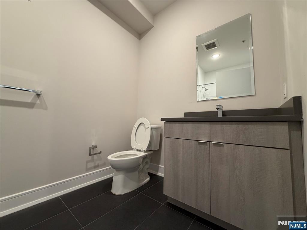 470 Main Street, Unit 508 Fort Lee, NJ 07024 - Photo 8 of 18 a bathroom with a granite countertop sink toilet and a mirror