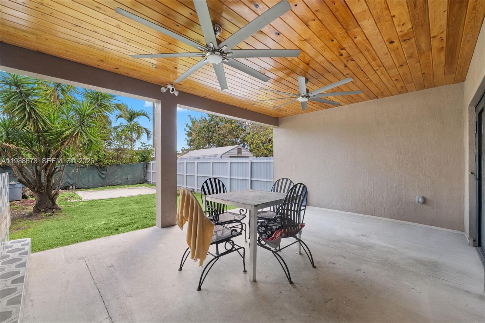 14888 Southwest 140th Street Miami, FL 33196 - Photo 29 of 76 a patio with table and chairs and couches with wooden floor and fence
