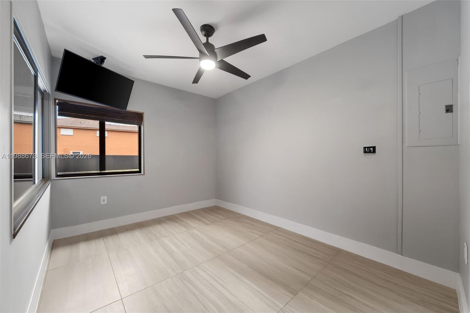 14888 Southwest 140th Street Miami, FL 33196 - Photo 39 of 76 an empty room with wooden floor fan and windows