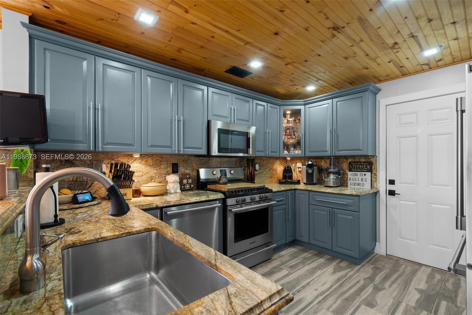 14888 Southwest 140th Street Miami, FL 33196 - Photo 43 of 76 a kitchen with granite countertop stainless steel appliances and wooden cabinets