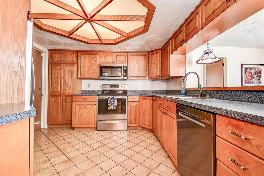 8601 139th Street Seminole, FL 33776 - Photo 29 of 47 a kitchen with stainless steel appliances granite countertop a stove sink and microwave