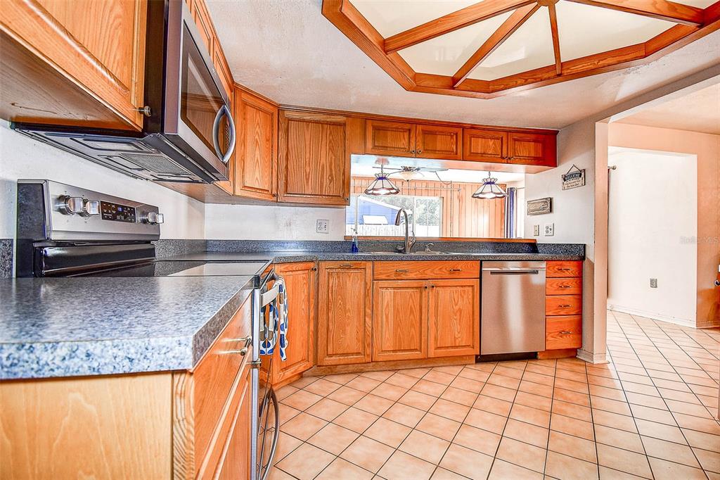 8601 139th Street Seminole, FL 33776 - Photo 32 of 47 a kitchen with granite countertop a sink a counter top space cabinets and stainless steel appliances