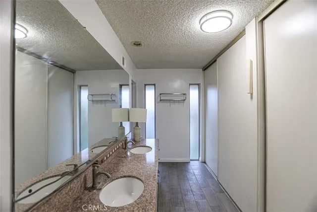 a bathroom with a granite countertop sink toilet and shower