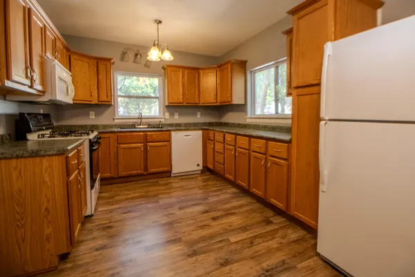 a kitchen with stainless steel appliances granite countertop a stove a sink dishwasher and a refrigerator