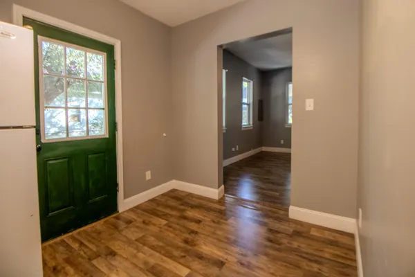a view of a hallway with wooden floor and closet