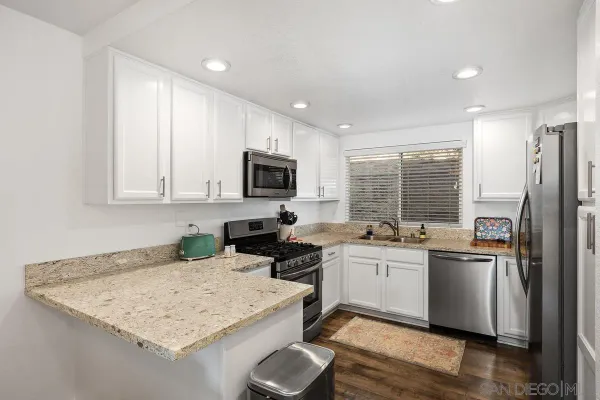 a kitchen with a sink a stove a refrigerator and cabinets