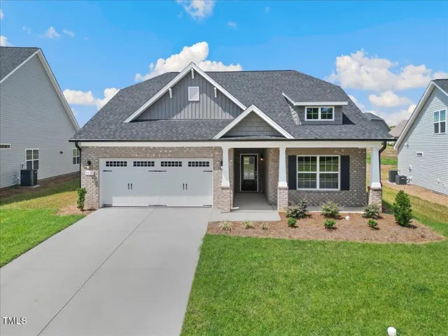 a kitchen with stainless steel appliances a refrigerator a stove a sink a dining table and chairs with wooden floor