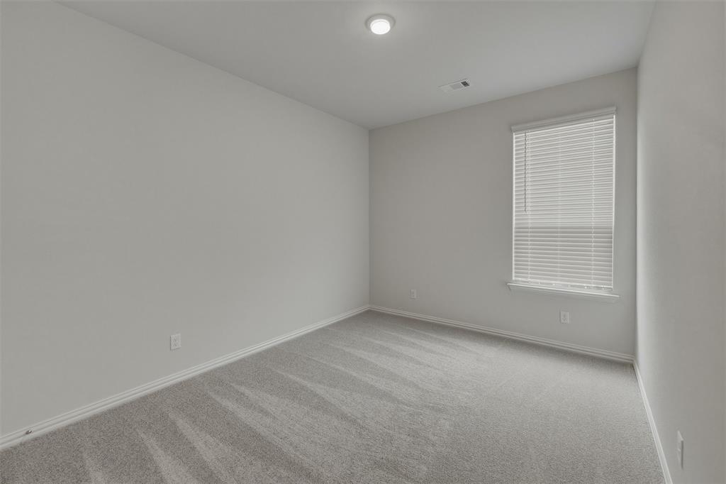 1325 Frio Drive Springtown, TX 76082 - Photo 10 of 24 Neutral wall color with baseboard trim, light gray carpet, and a single window featuring horizontal blinds