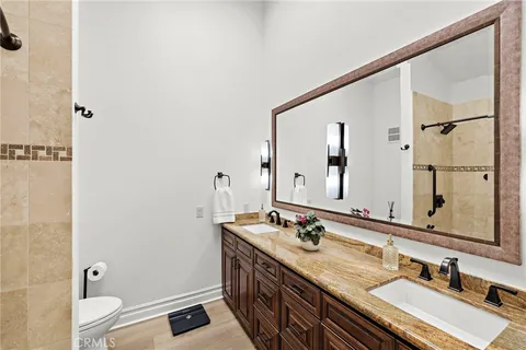 a bathroom with a granite countertop sink a mirror and a shower