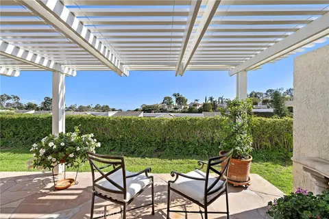 a view of balcony with chairs and table under an umbrella