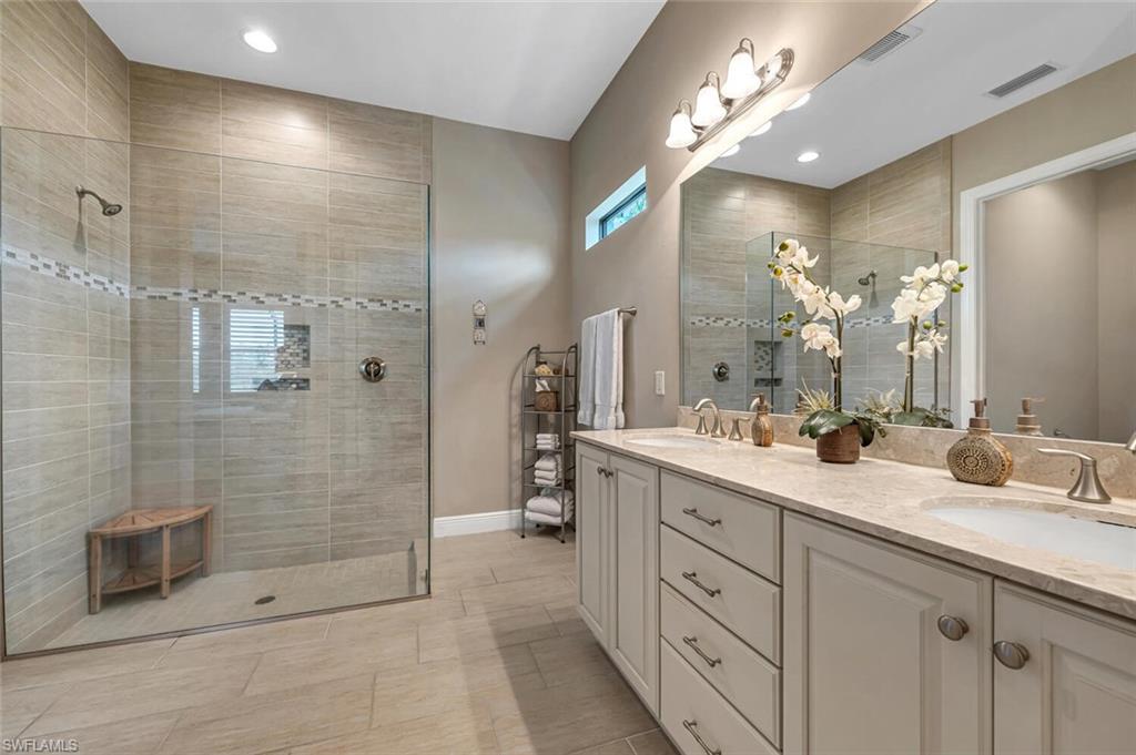 4741 Formosa Drive Naples, FL 34119 - Photo 16 of 18 a spacious bathroom with double sink a shower and a mirror